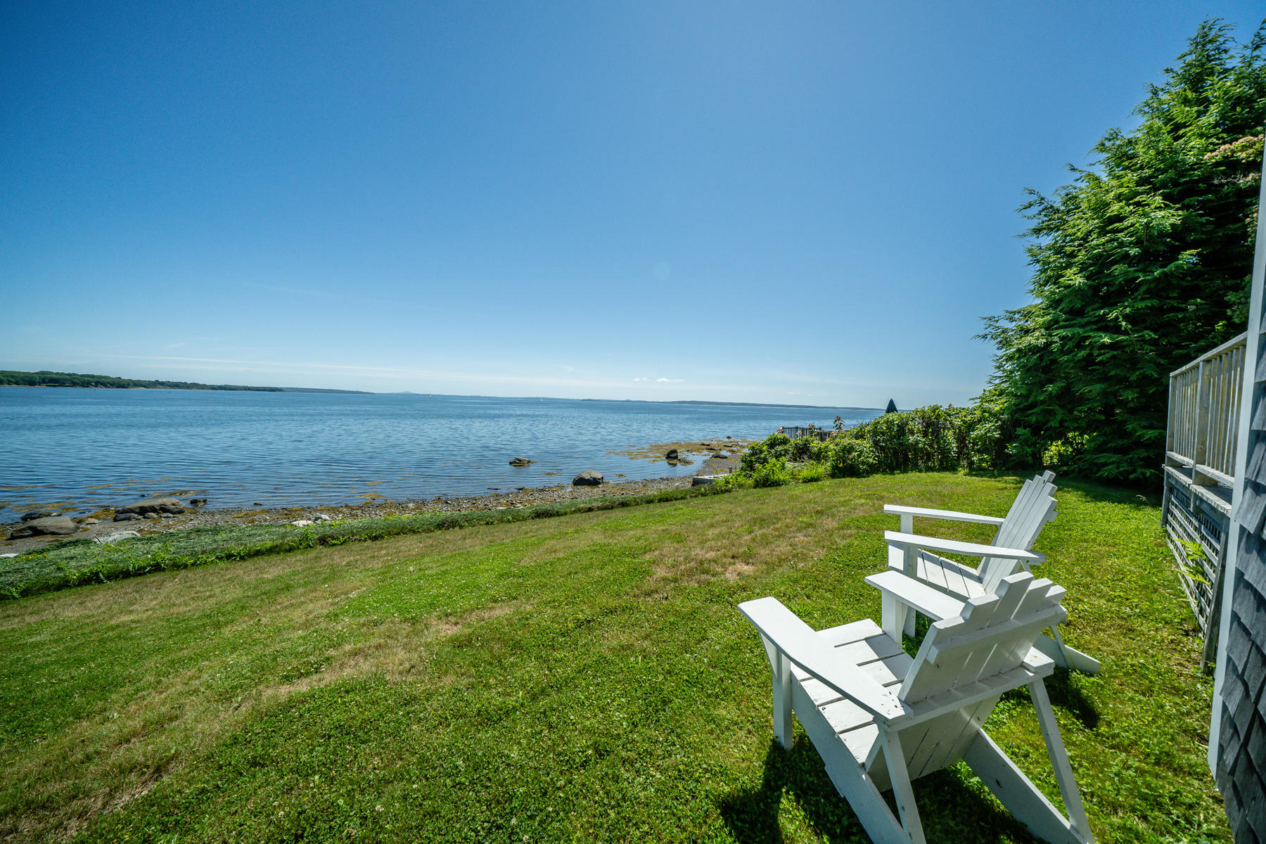 Oceanfront home for sale with ocean-facing windows that showcase the passing sailboat traffic - Belfast, Maine
